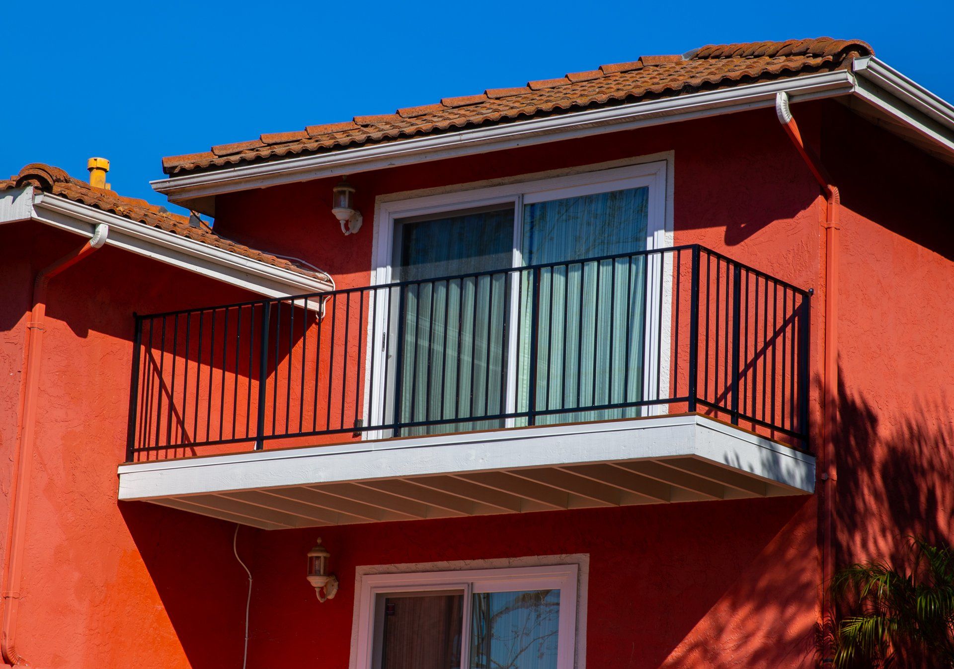 A red house with a balcony on the second floor