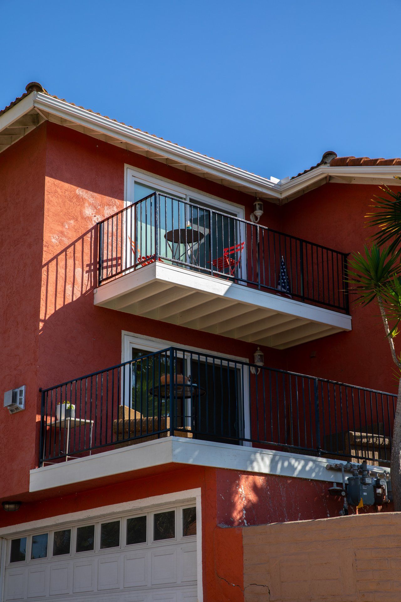 A red house with a balcony and a garage