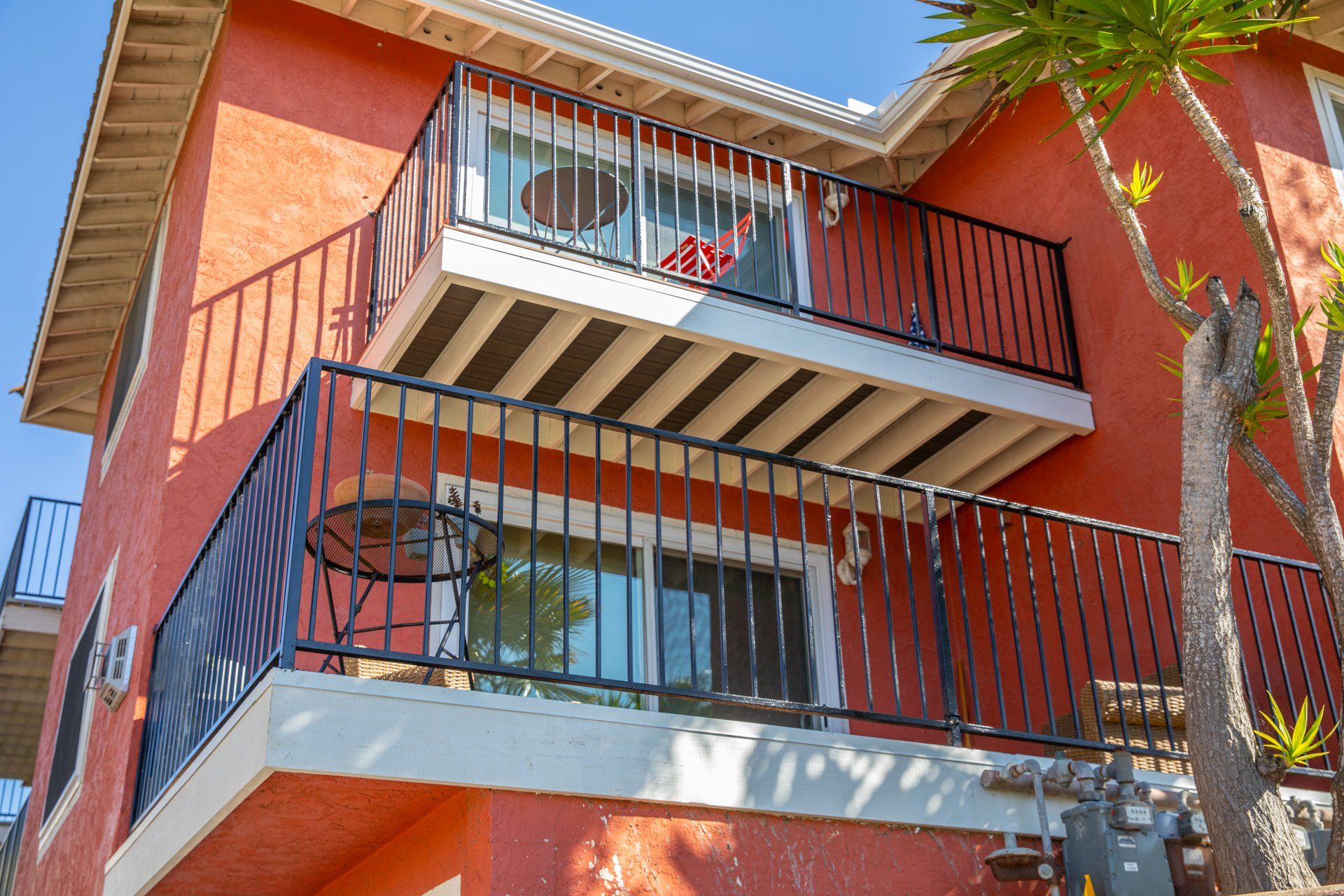 A red building with a balcony with a black railing
