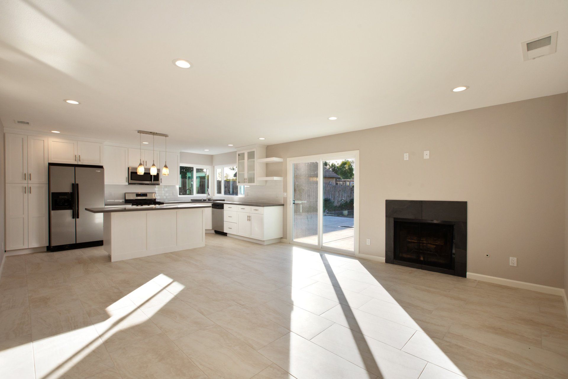 An empty kitchen with stainless steel appliances and a fireplace