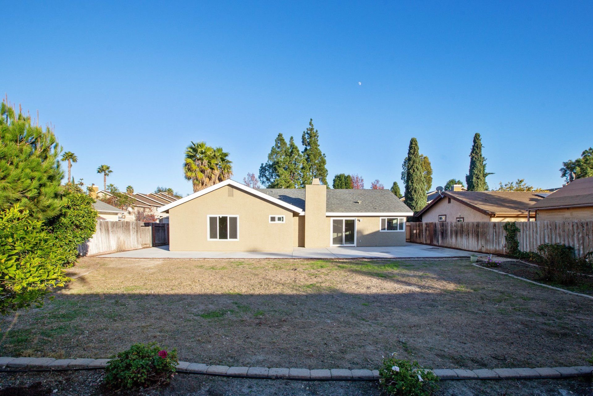 The backyard of a house with a fence surrounding it