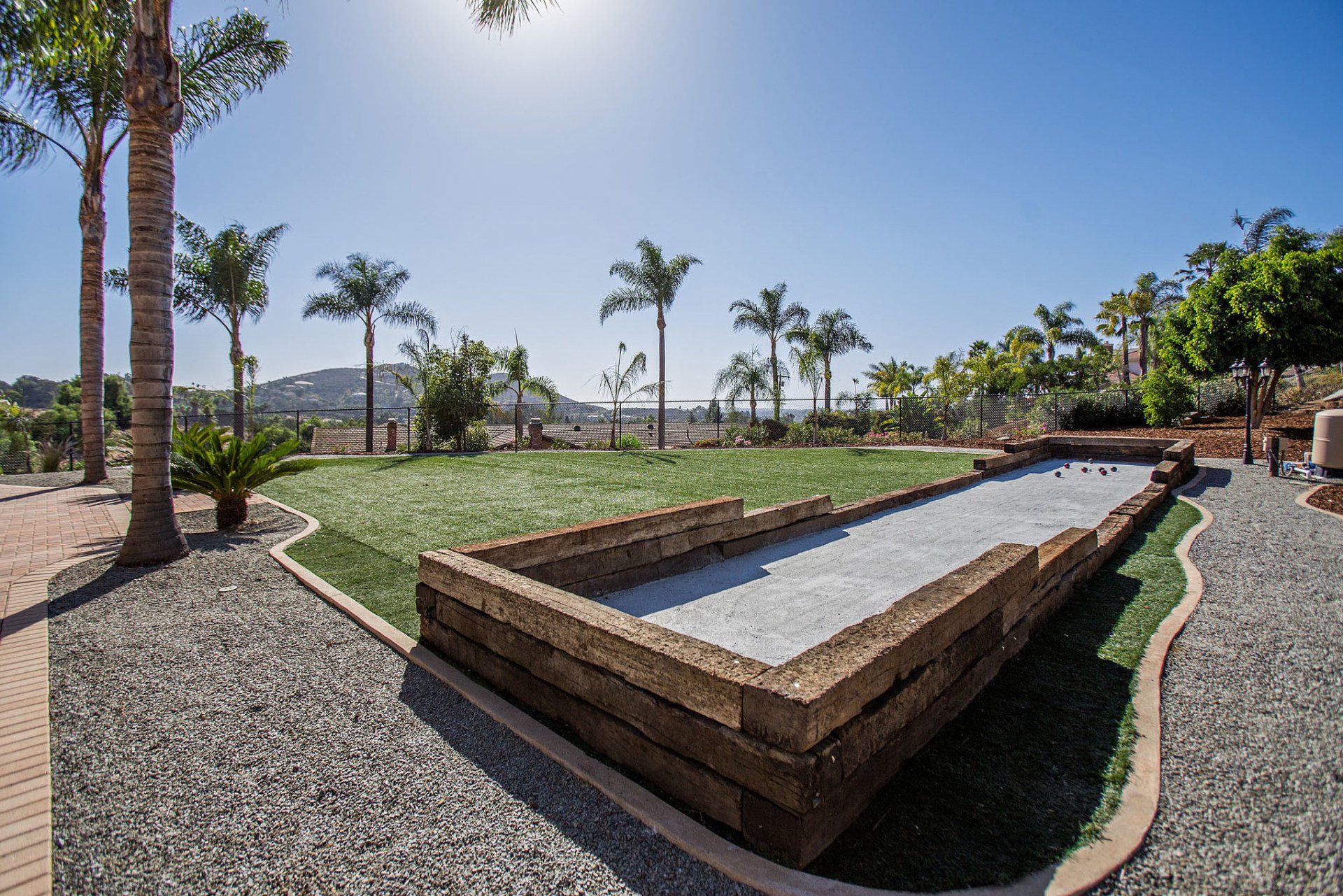 A bowling alley in a park with palm trees in the background