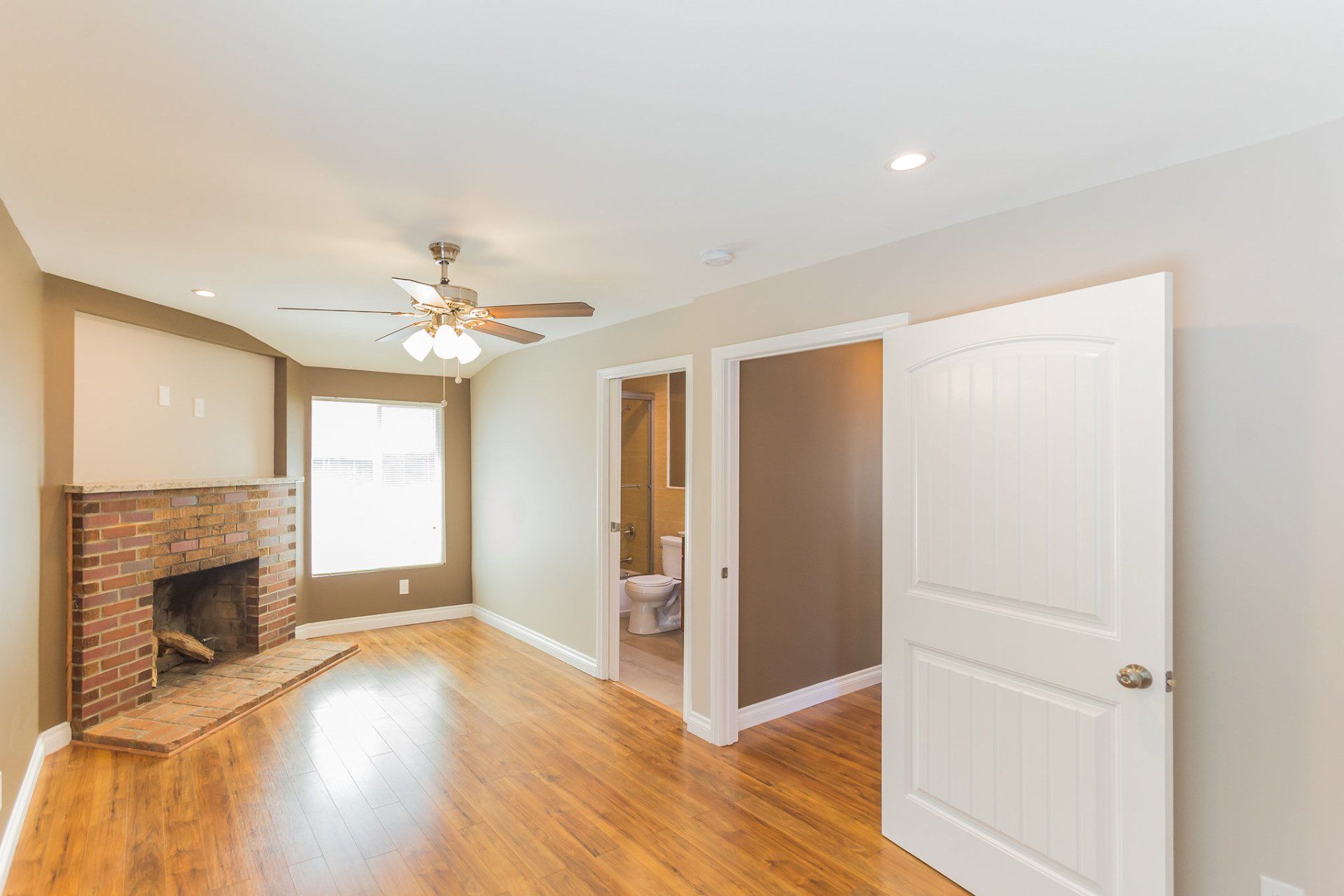 A living room with a fireplace and a ceiling fan