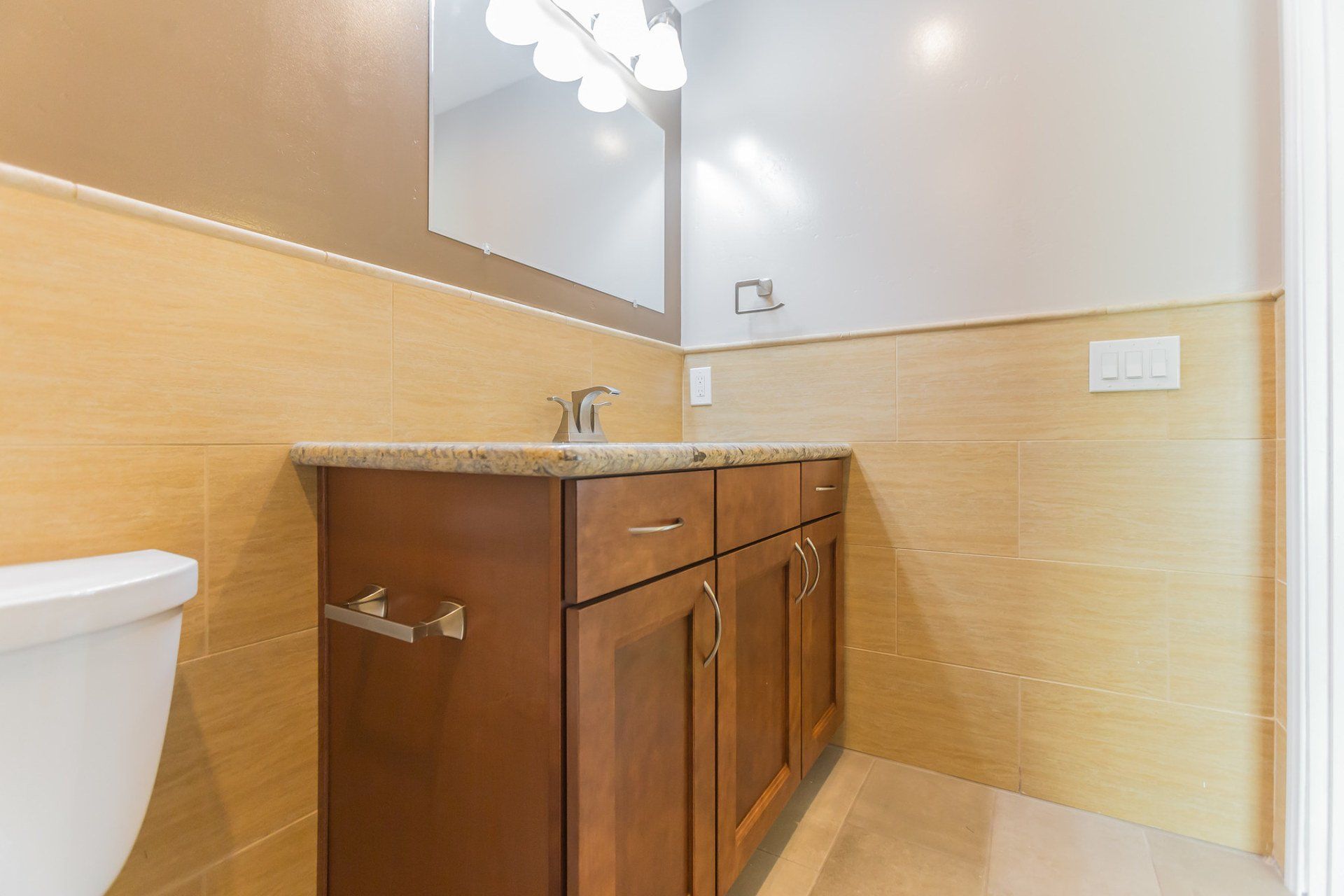 A bathroom with a toilet a sink and a mirror