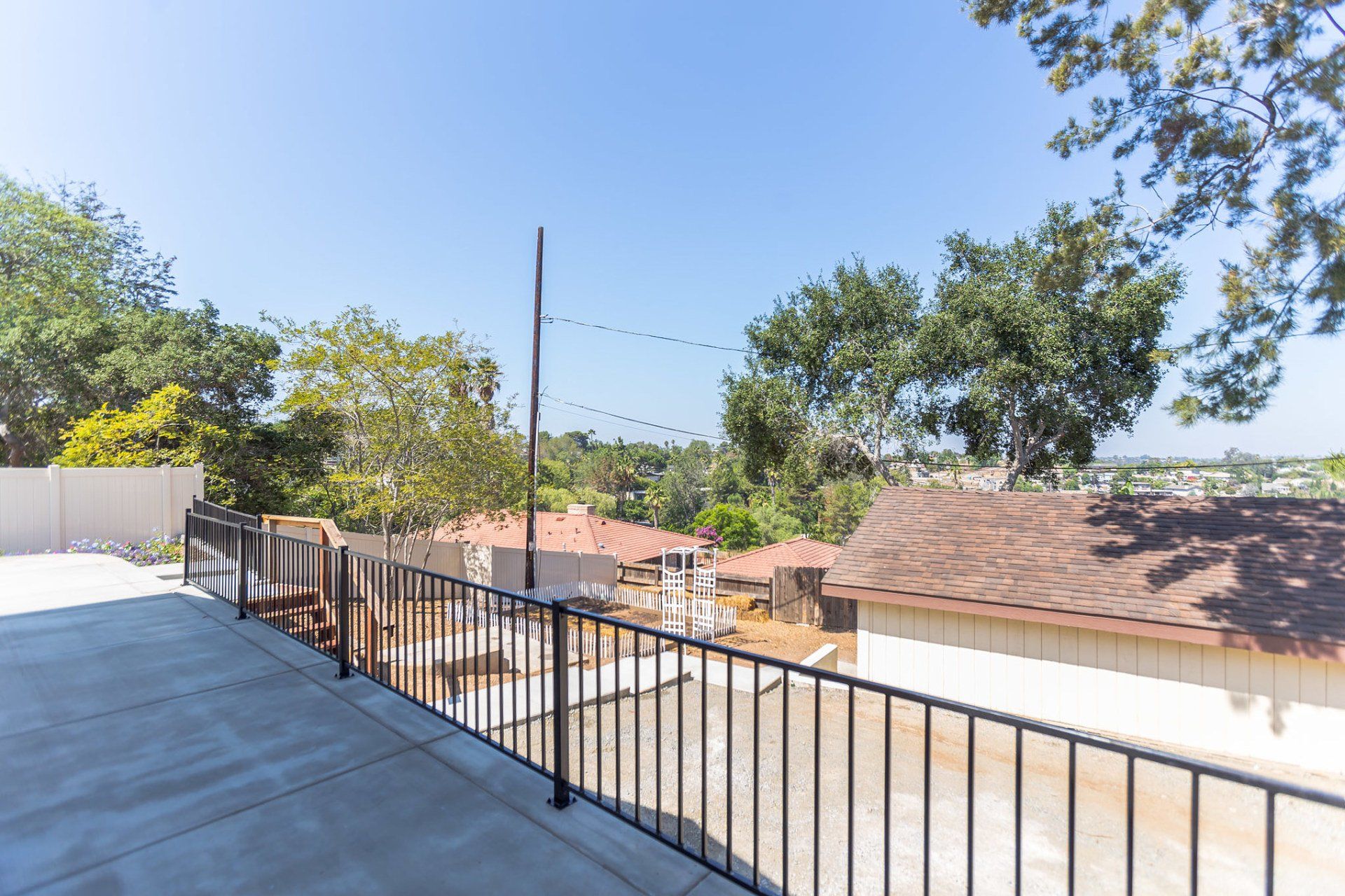 A view of a city from a balcony with a metal railing