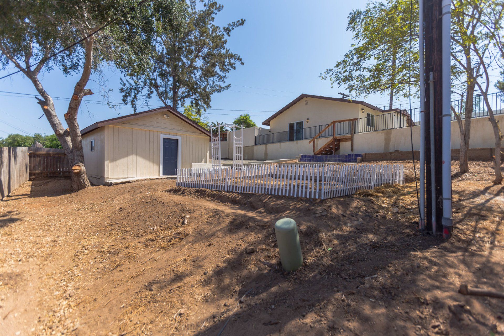 A fenced in yard with a house in the background
