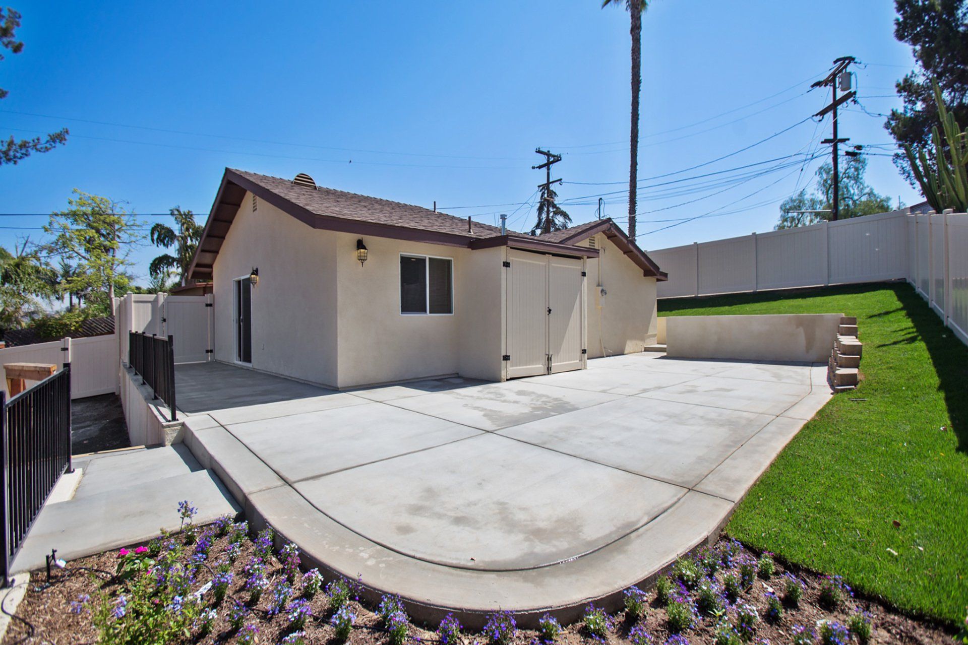 A house with a concrete driveway and a fence around it