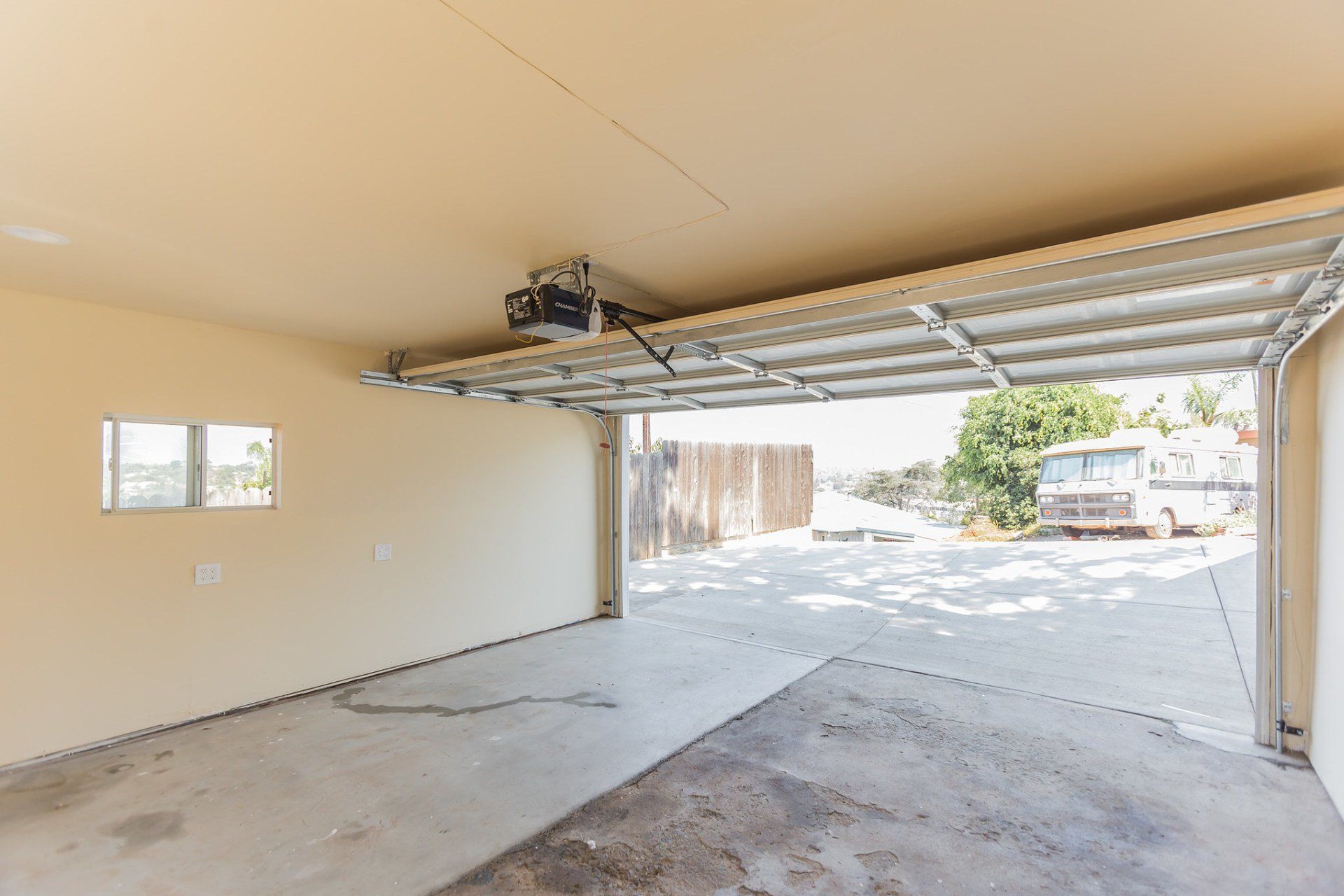 An empty garage with the door open and a window