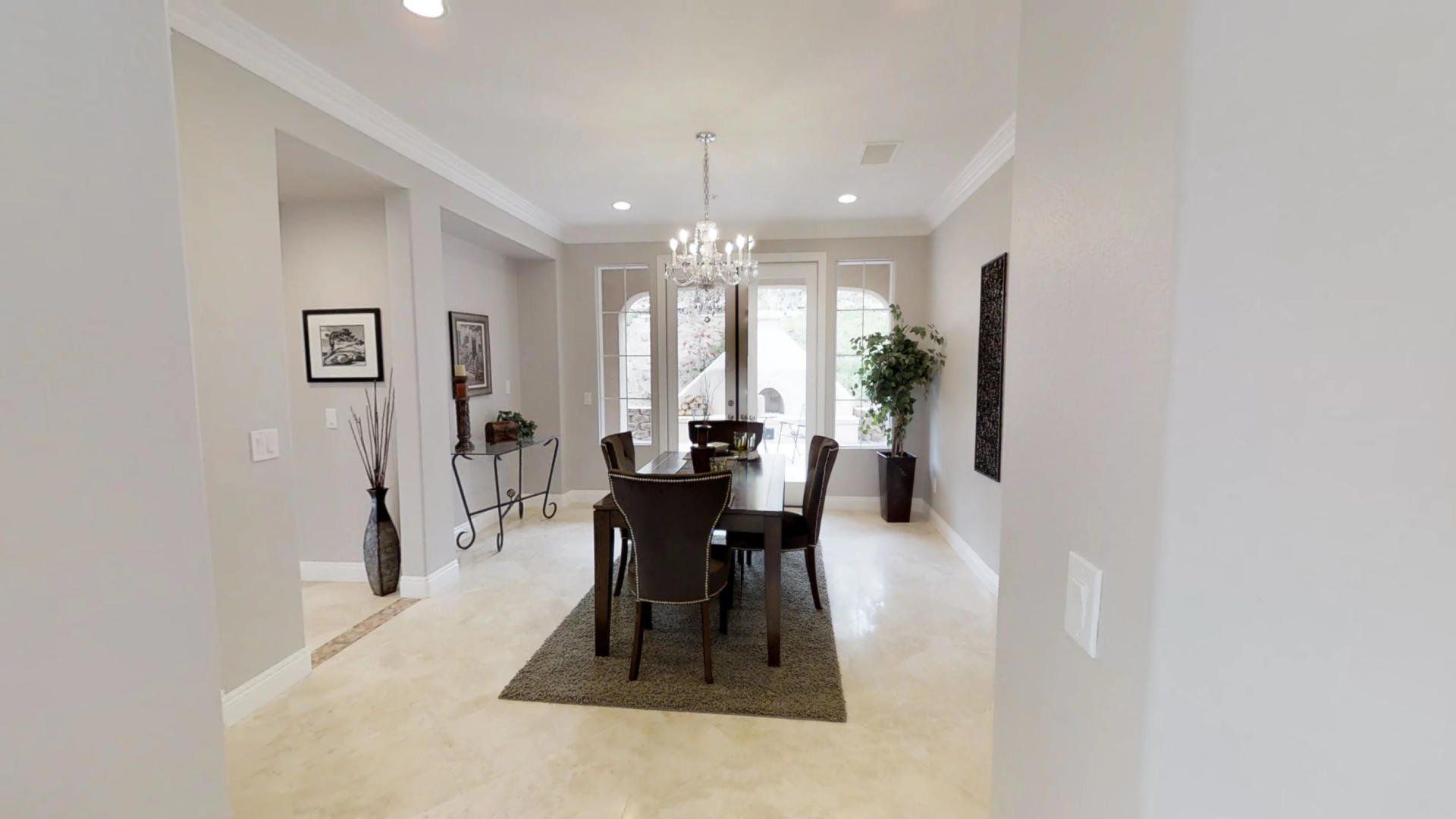A dining room with a table and chairs and a chandelier.