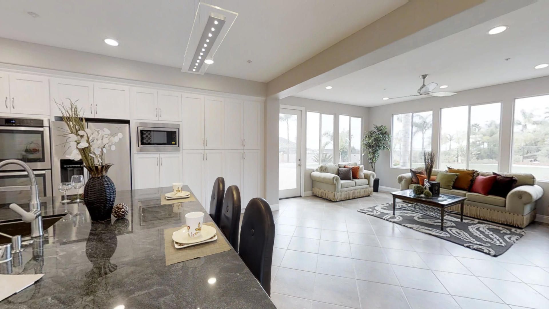 A kitchen and living room in a house with a lot of windows.