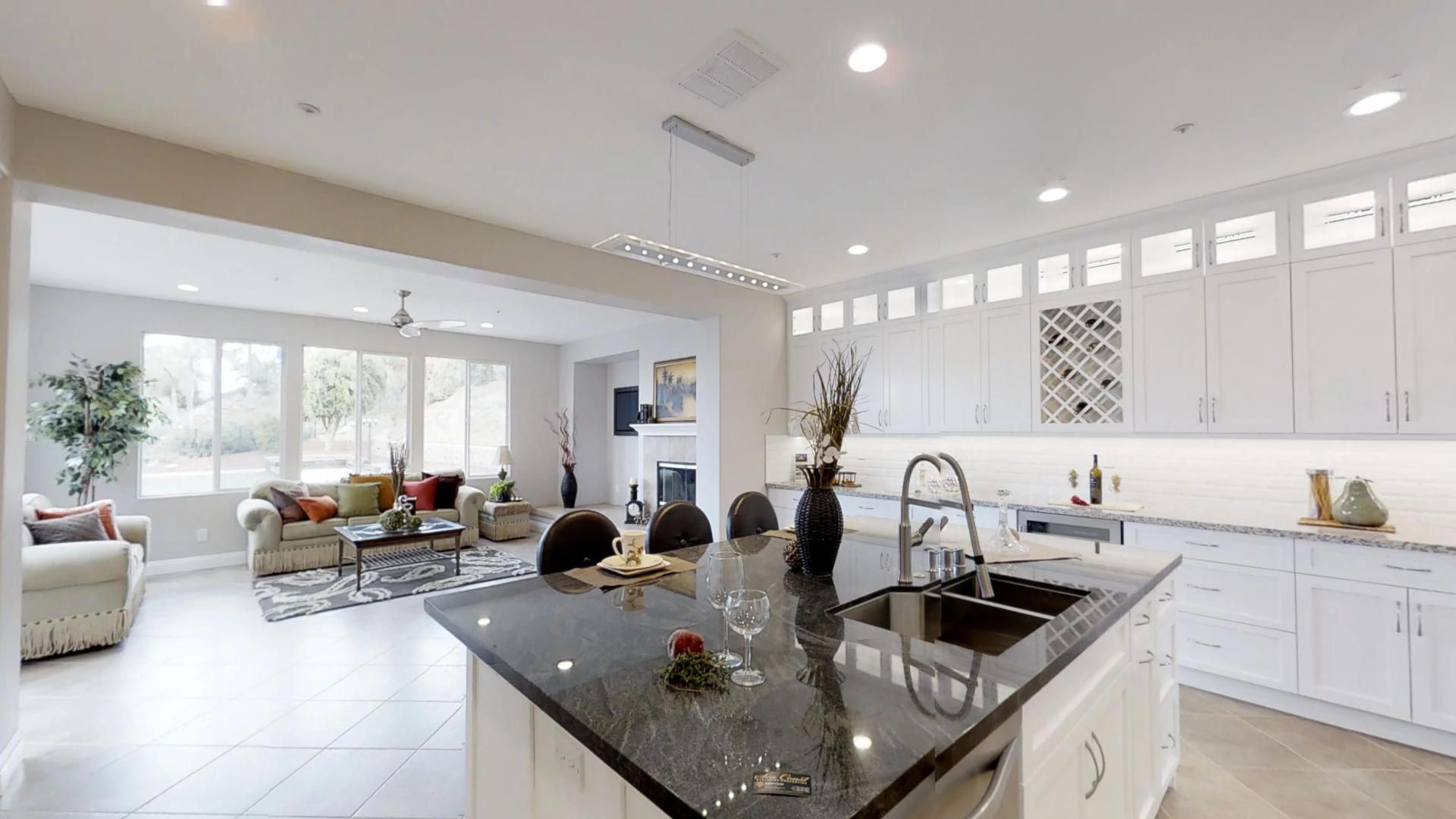 A kitchen with a large island and a sink in a house.