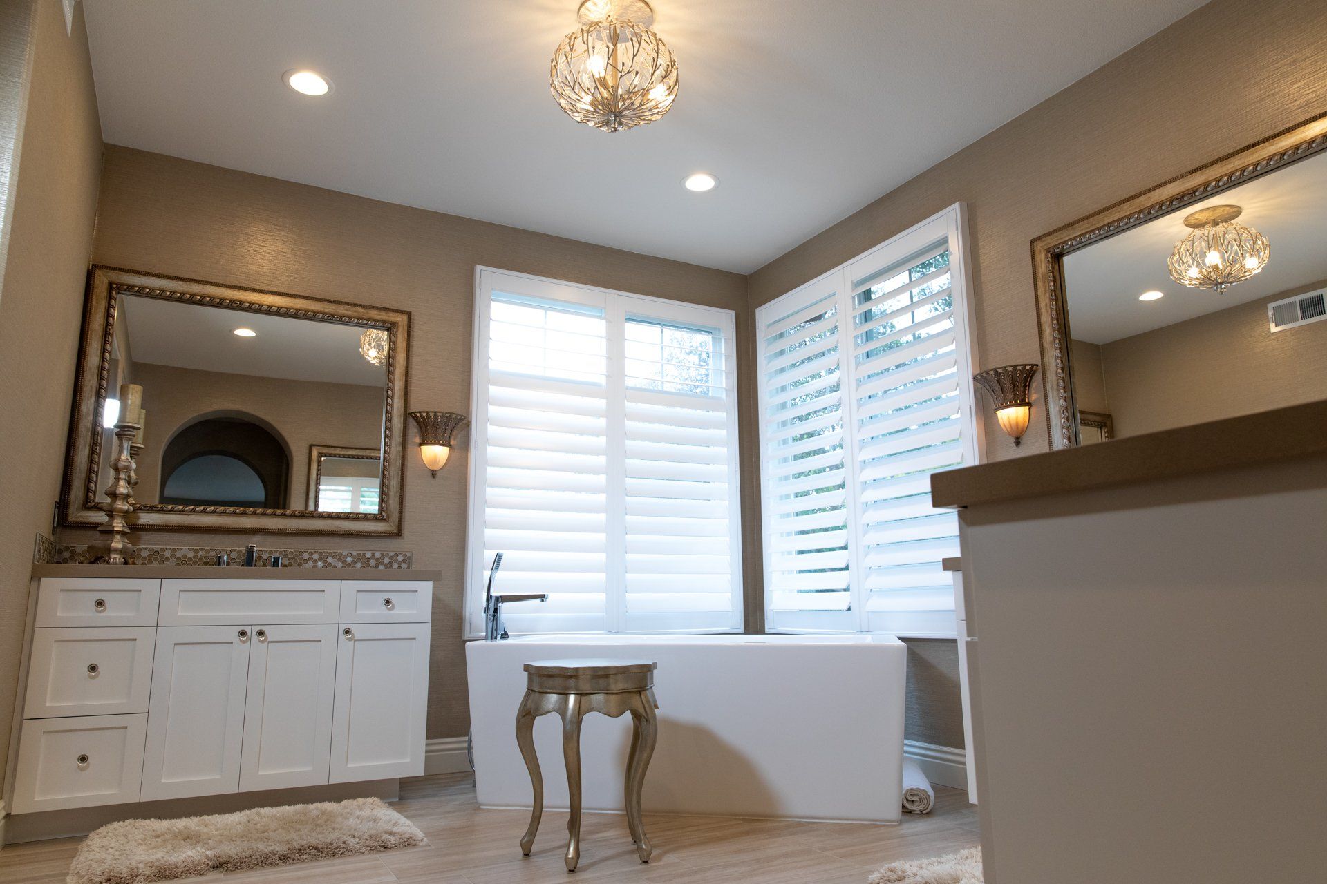 A bathroom with a bathtub and two mirrors