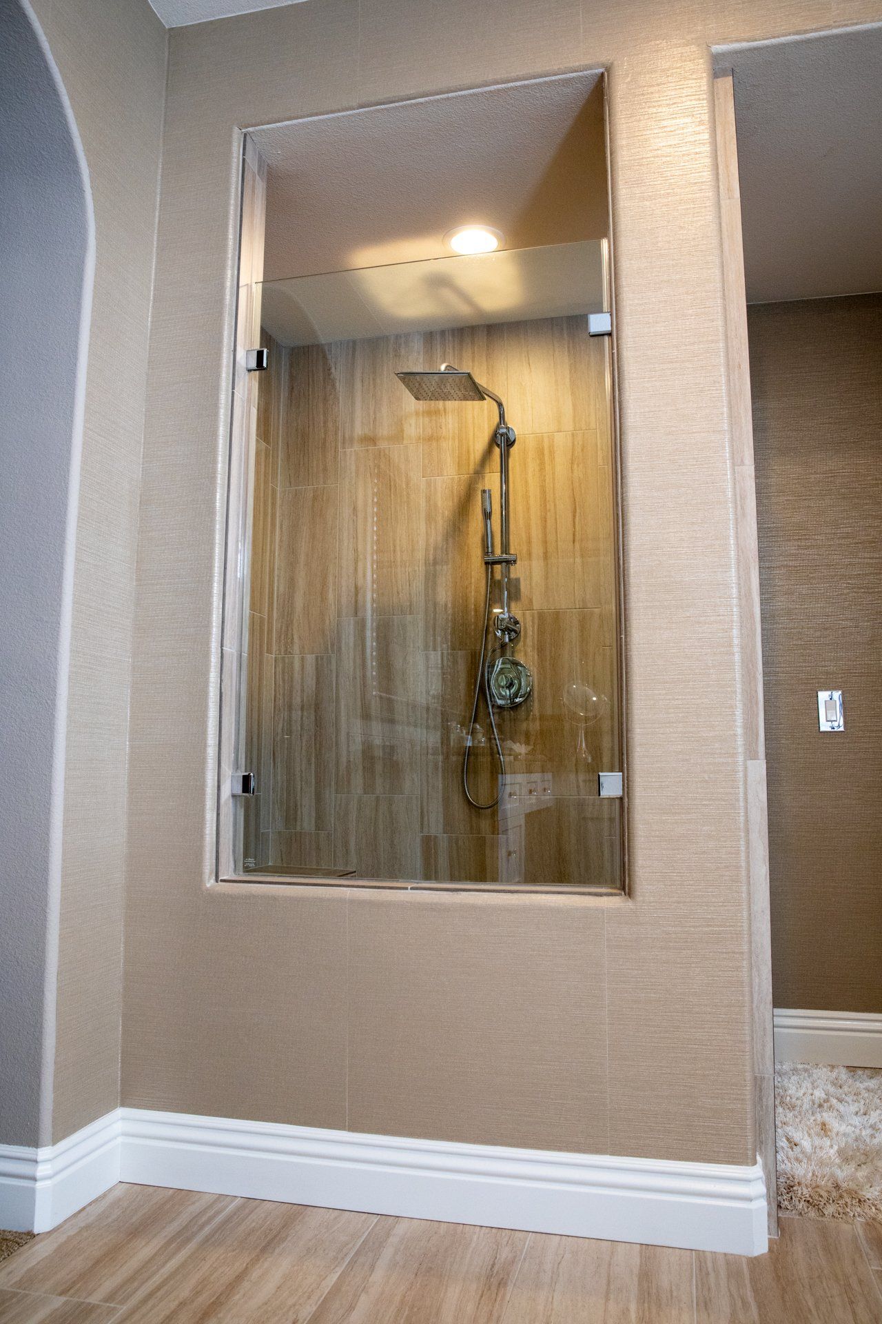 A bathroom with a walk in shower with a glass door