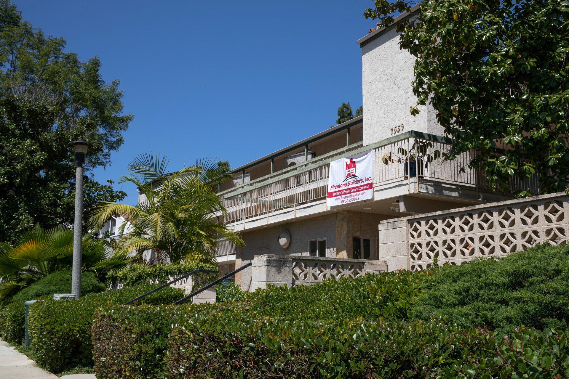 A white building with a red and white flag on the balcony