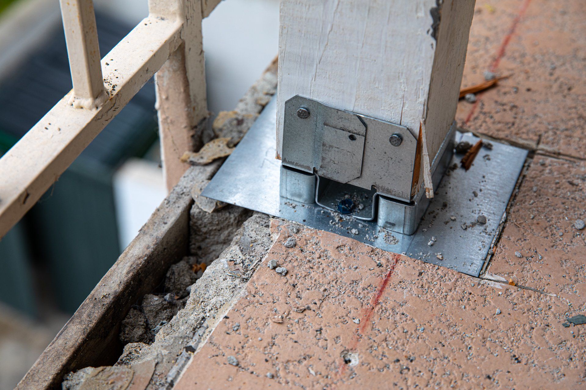 A metal bracket is attached to a concrete post on a balcony