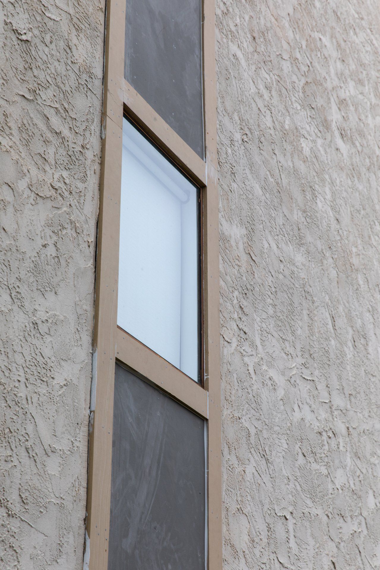 A window with a screen on the side of a building