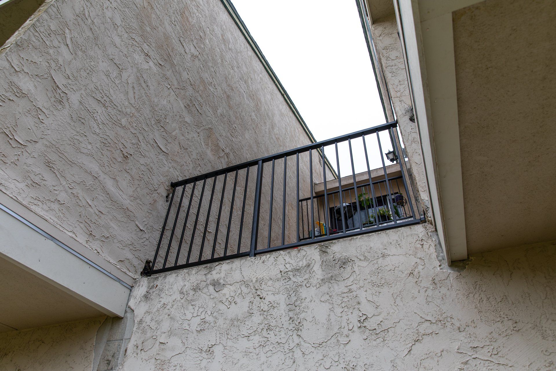 Looking up at a balcony with a metal railing