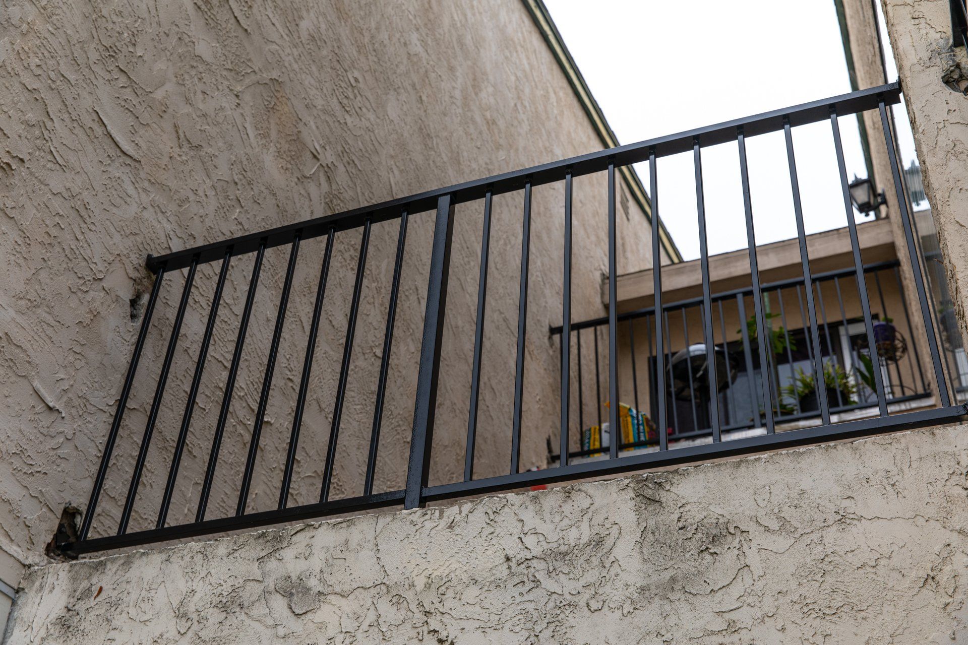 A balcony with a metal railing on the side of a building