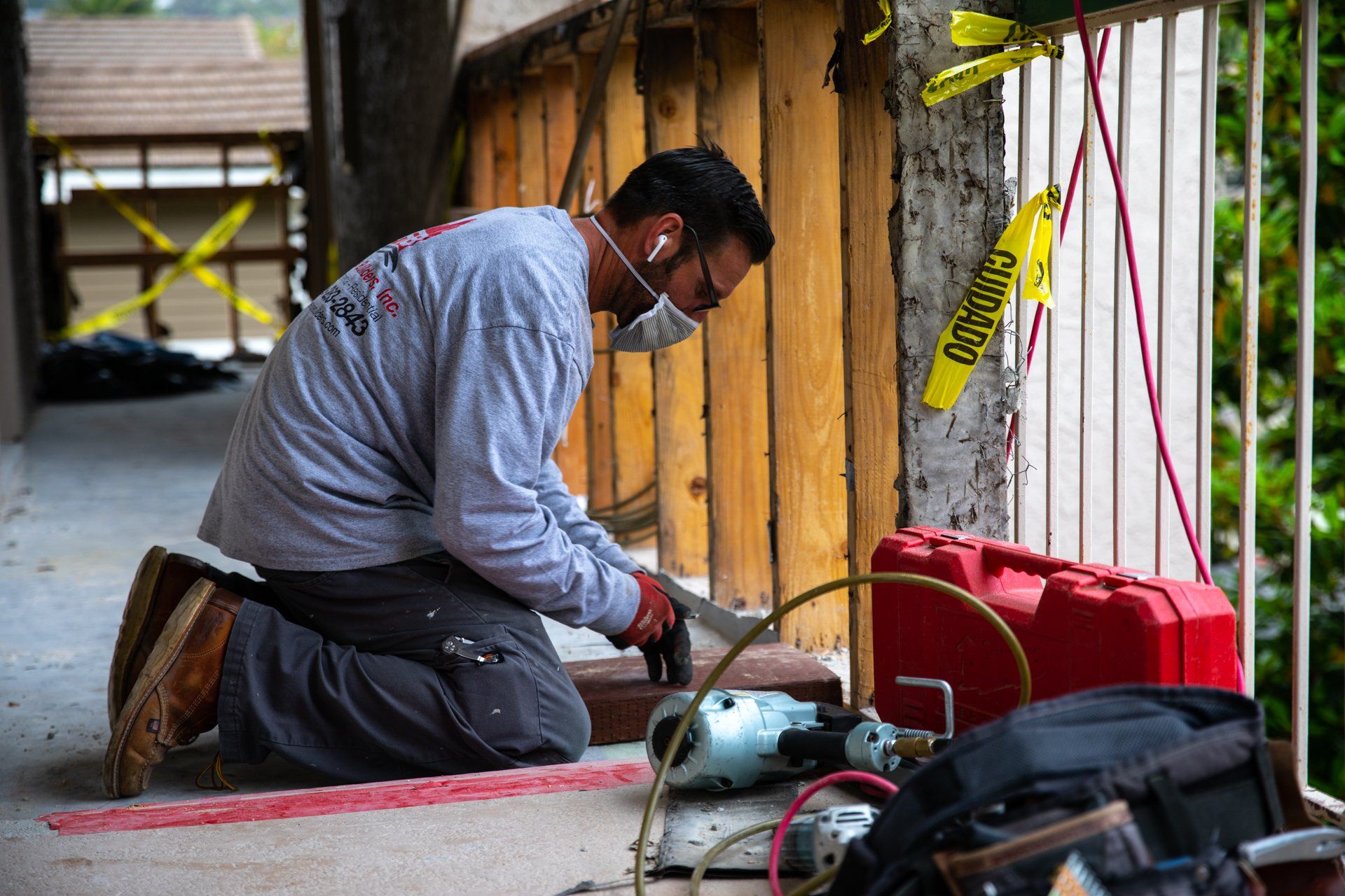 A man wearing a mask is working on a concrete wall