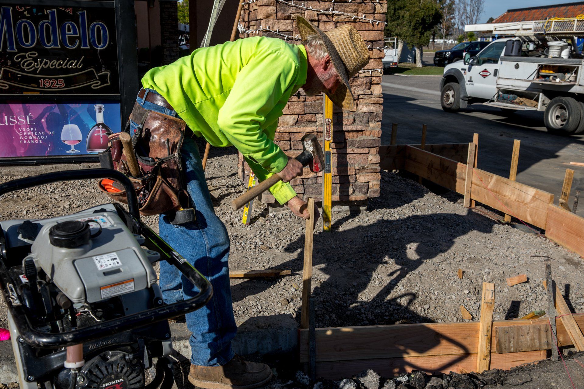 A man in a neon yellow jacket is working on a construction site