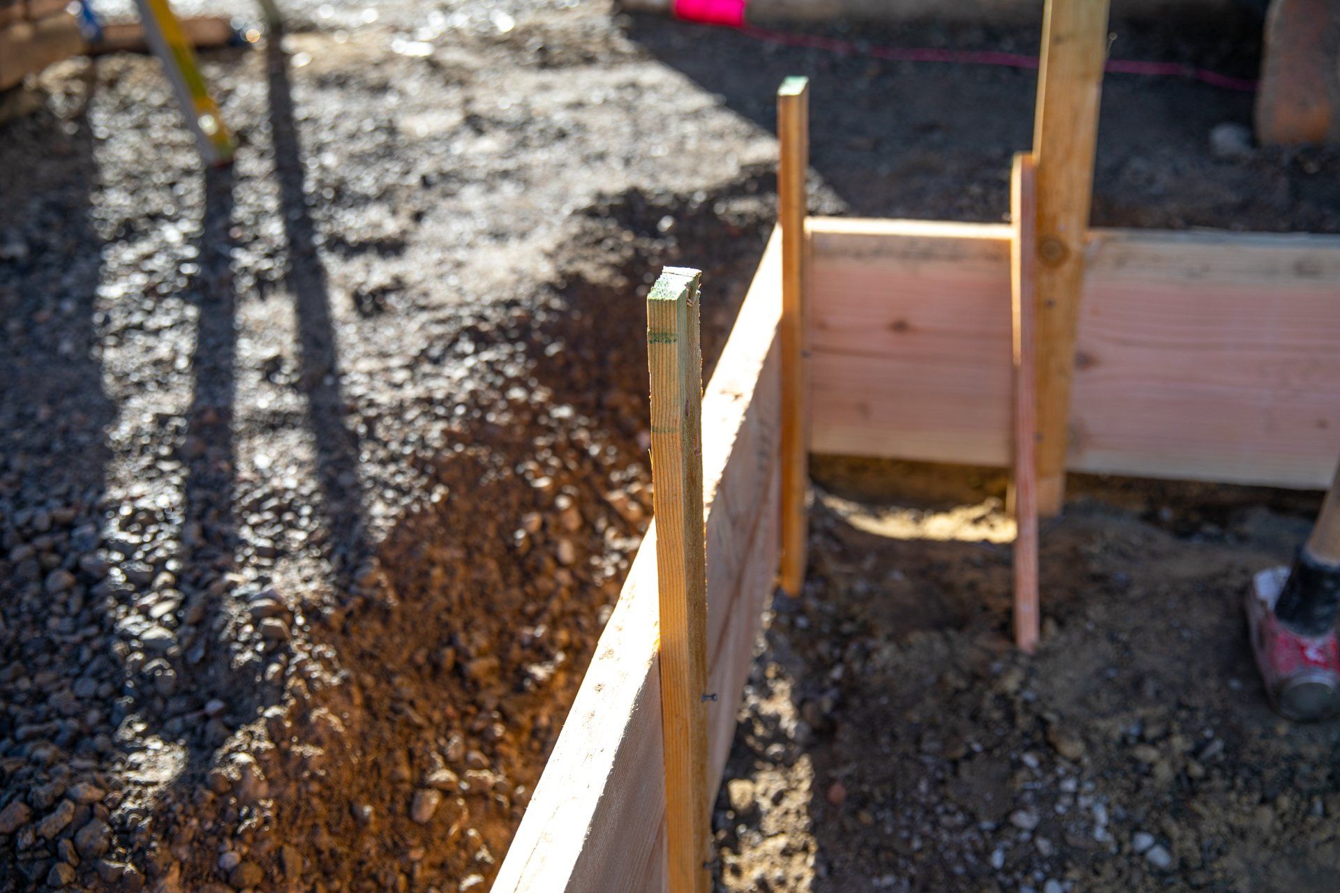A wooden fence is being built in the dirt