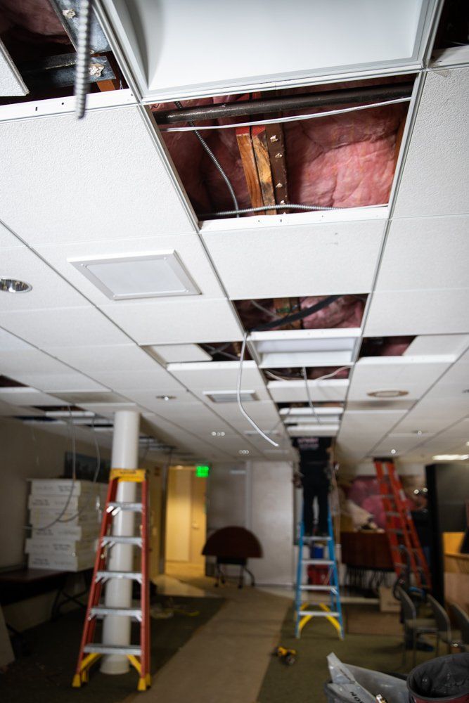 A man is working on the ceiling of a building.