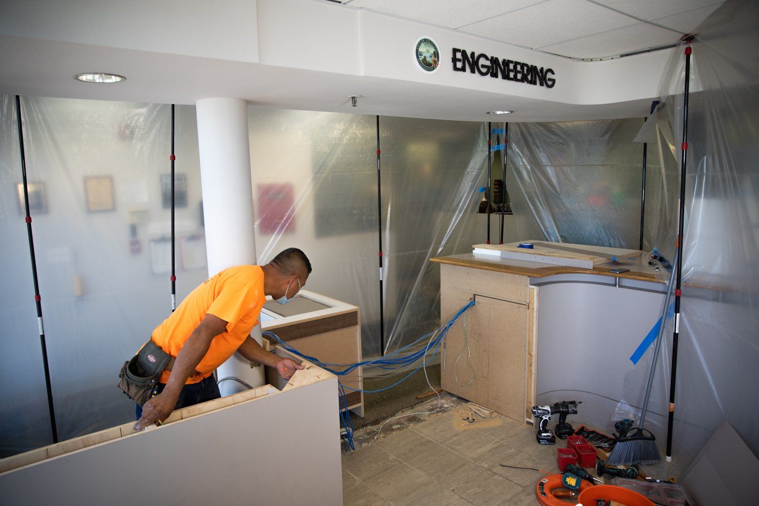 A man is working in a room with a sign that says engineering.