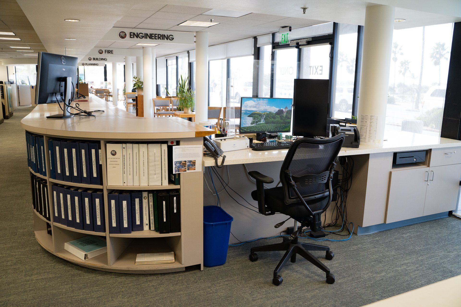 A desk with a computer and a chair in a library