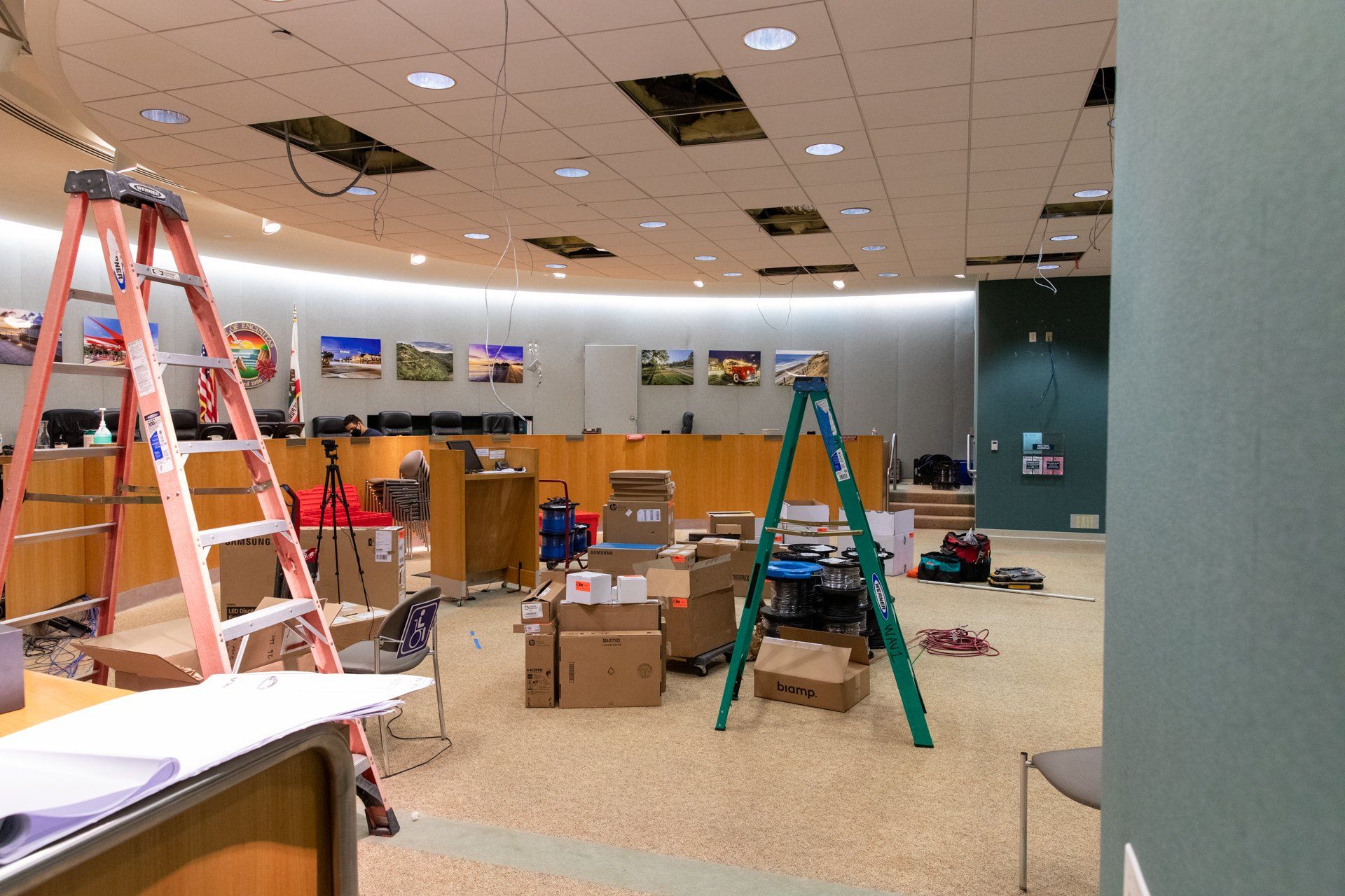 An empty room with a ladder and boxes on the floor