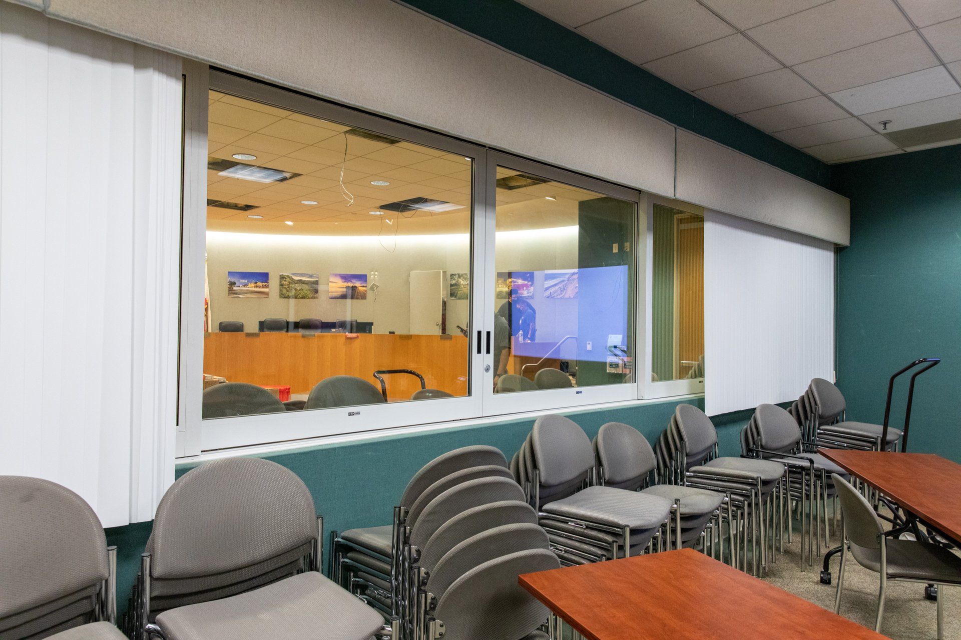 A conference room with tables and chairs and a large window
