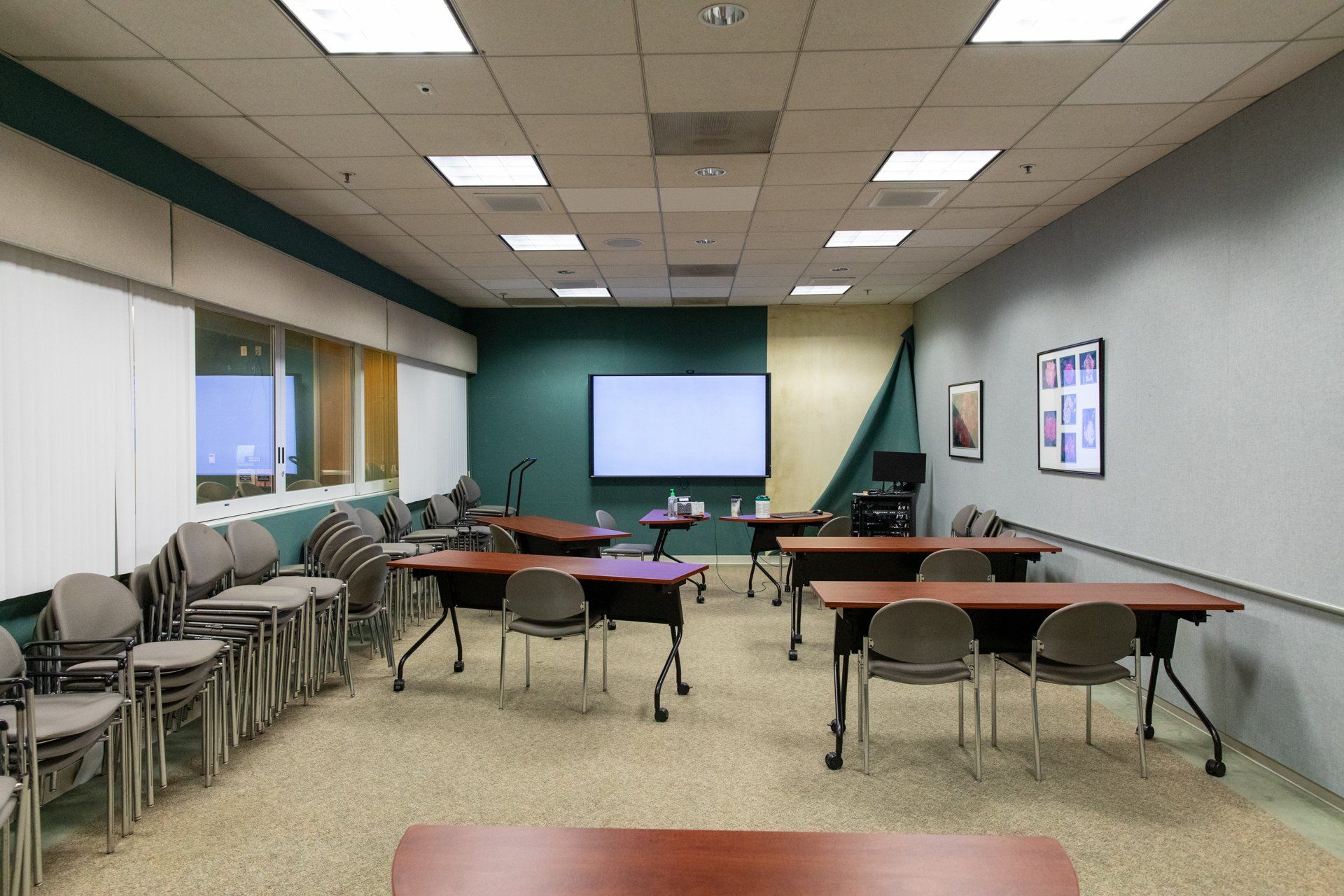 A classroom with tables and chairs and a whiteboard