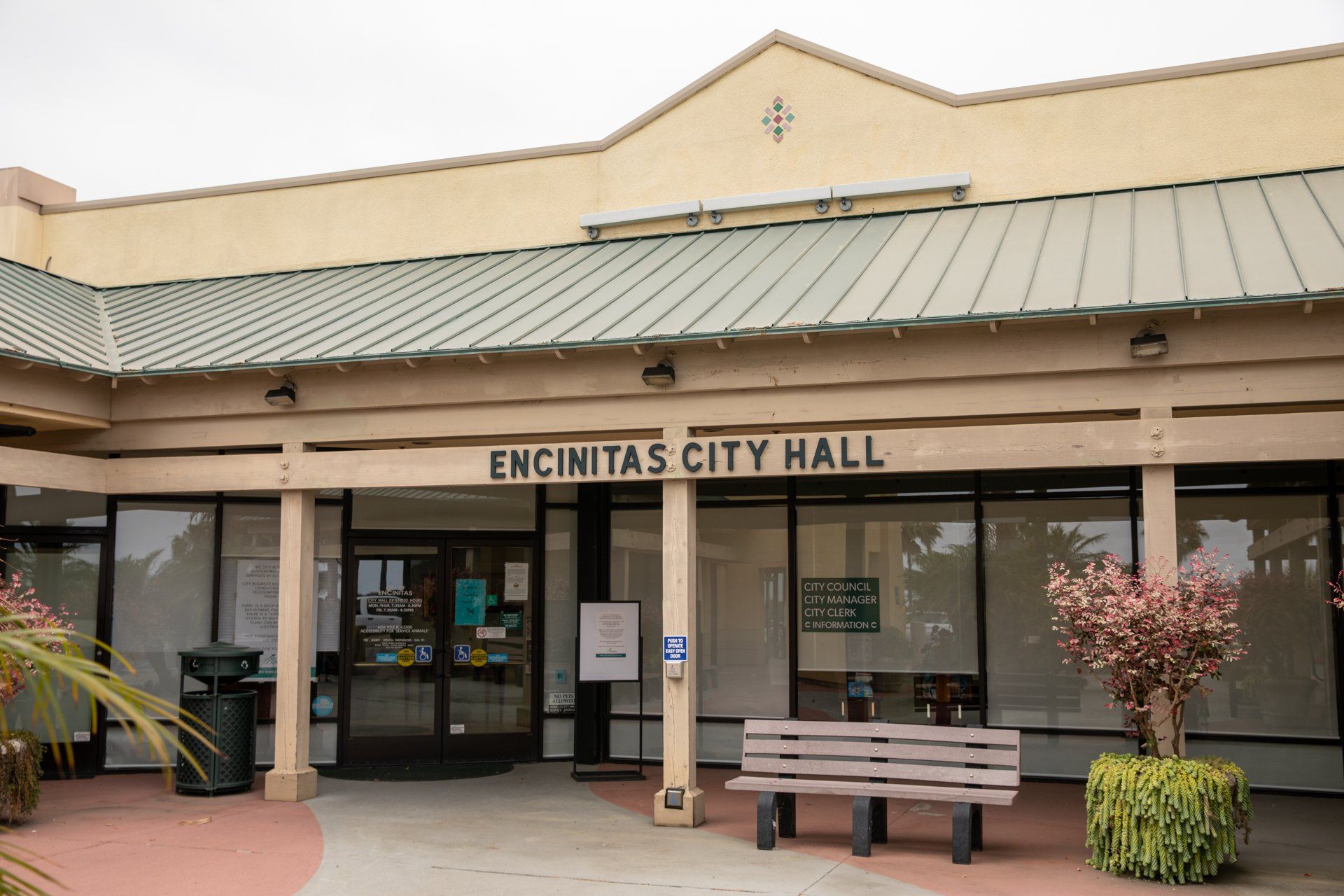 The encinitas city hall has a bench in front of it
