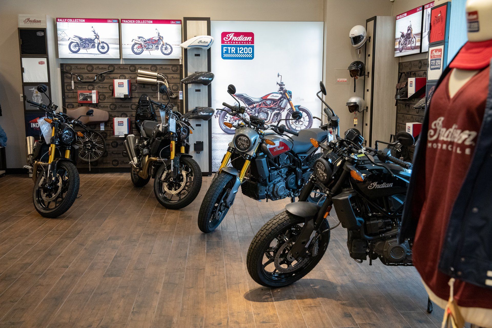 A row of motorcycles are parked in a showroom.