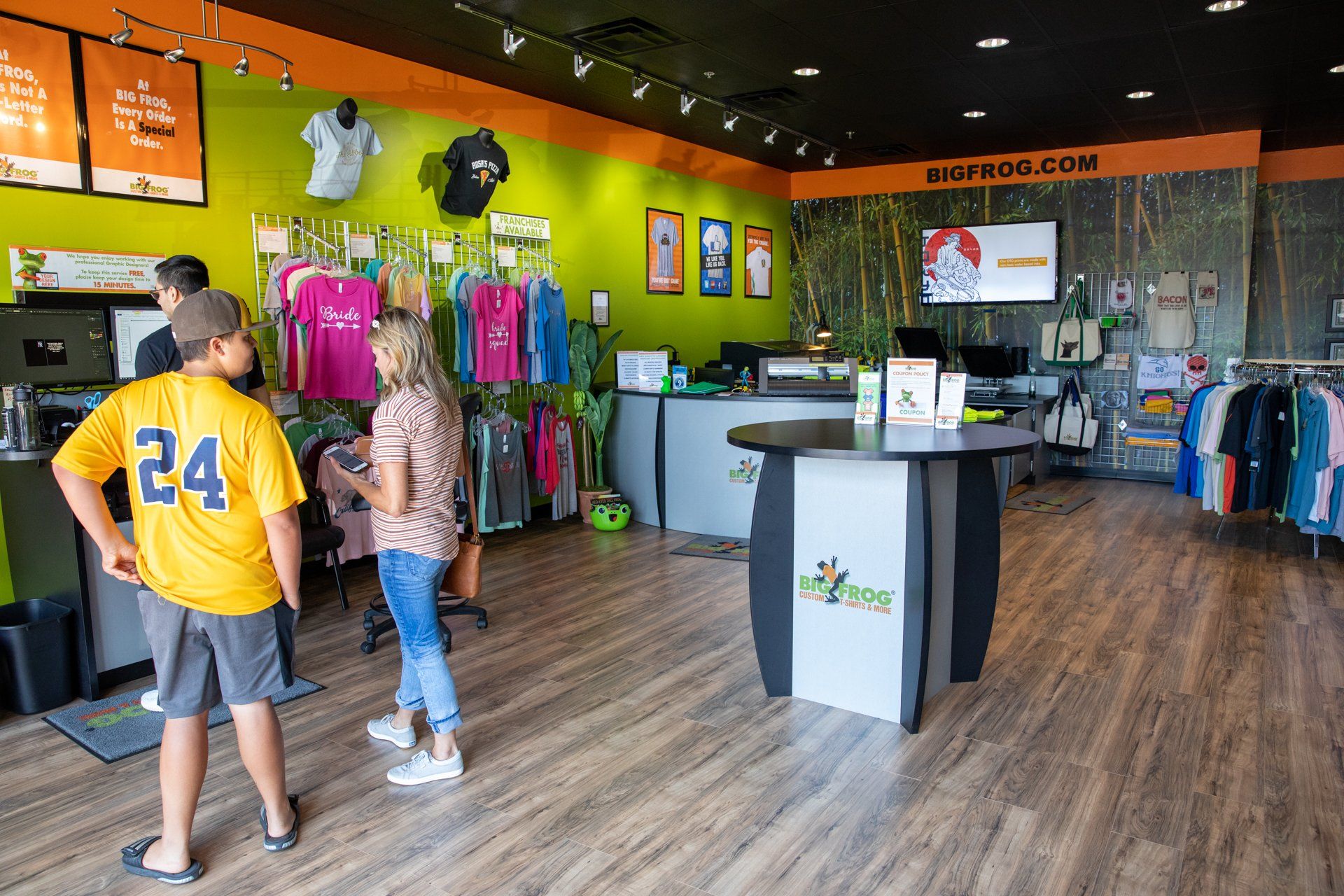 A man in a yellow shirt with the number 24 on it is standing in a store.