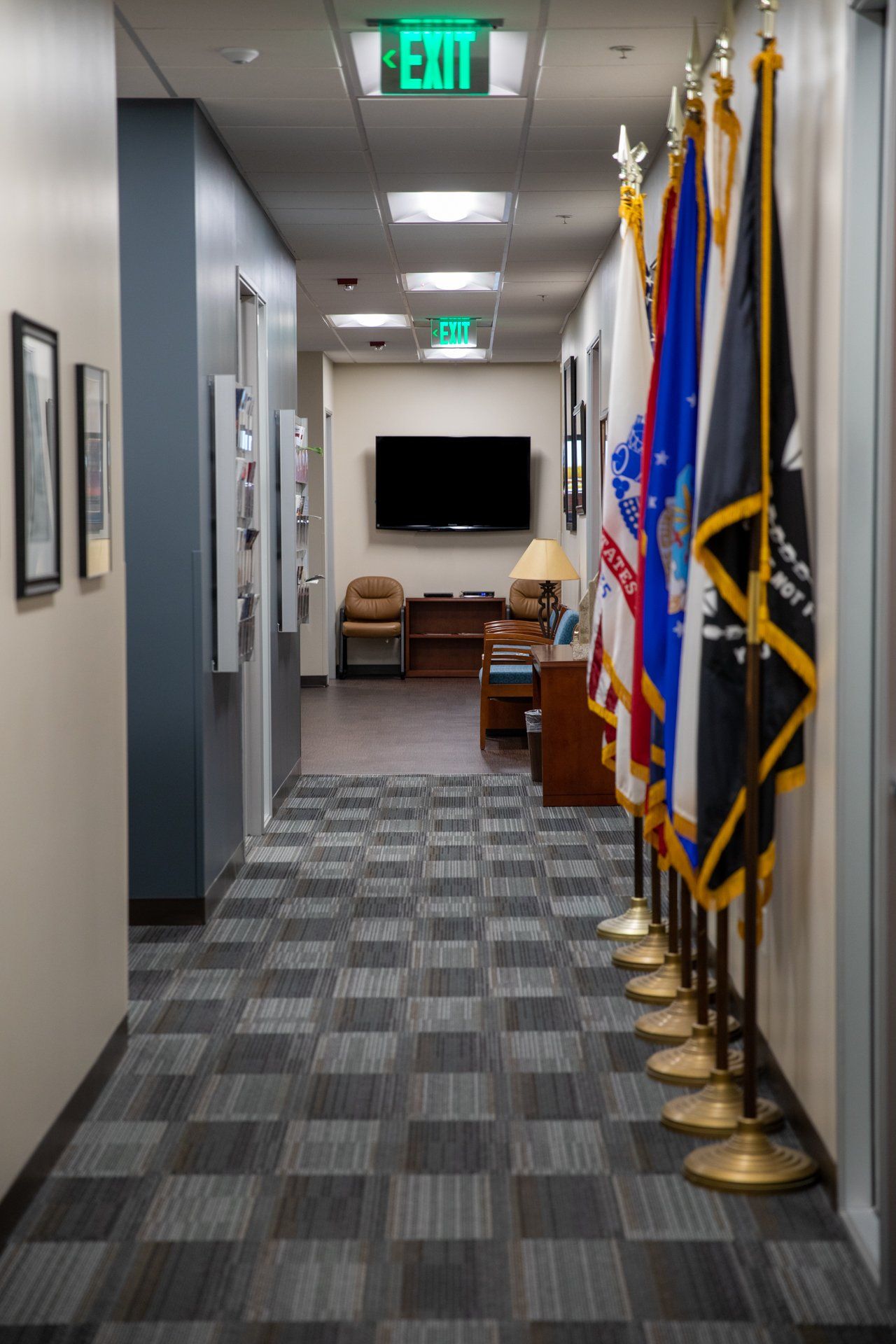 A hallway with flags and an exit sign