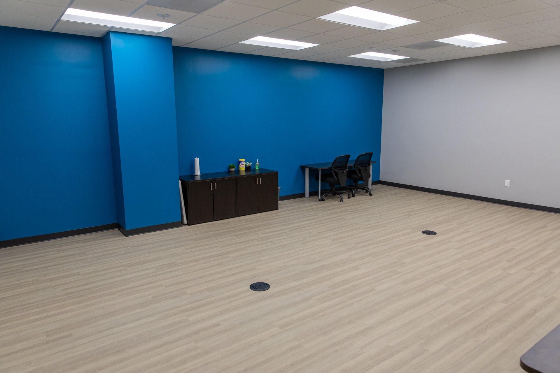 An empty room with blue walls and wooden floors
