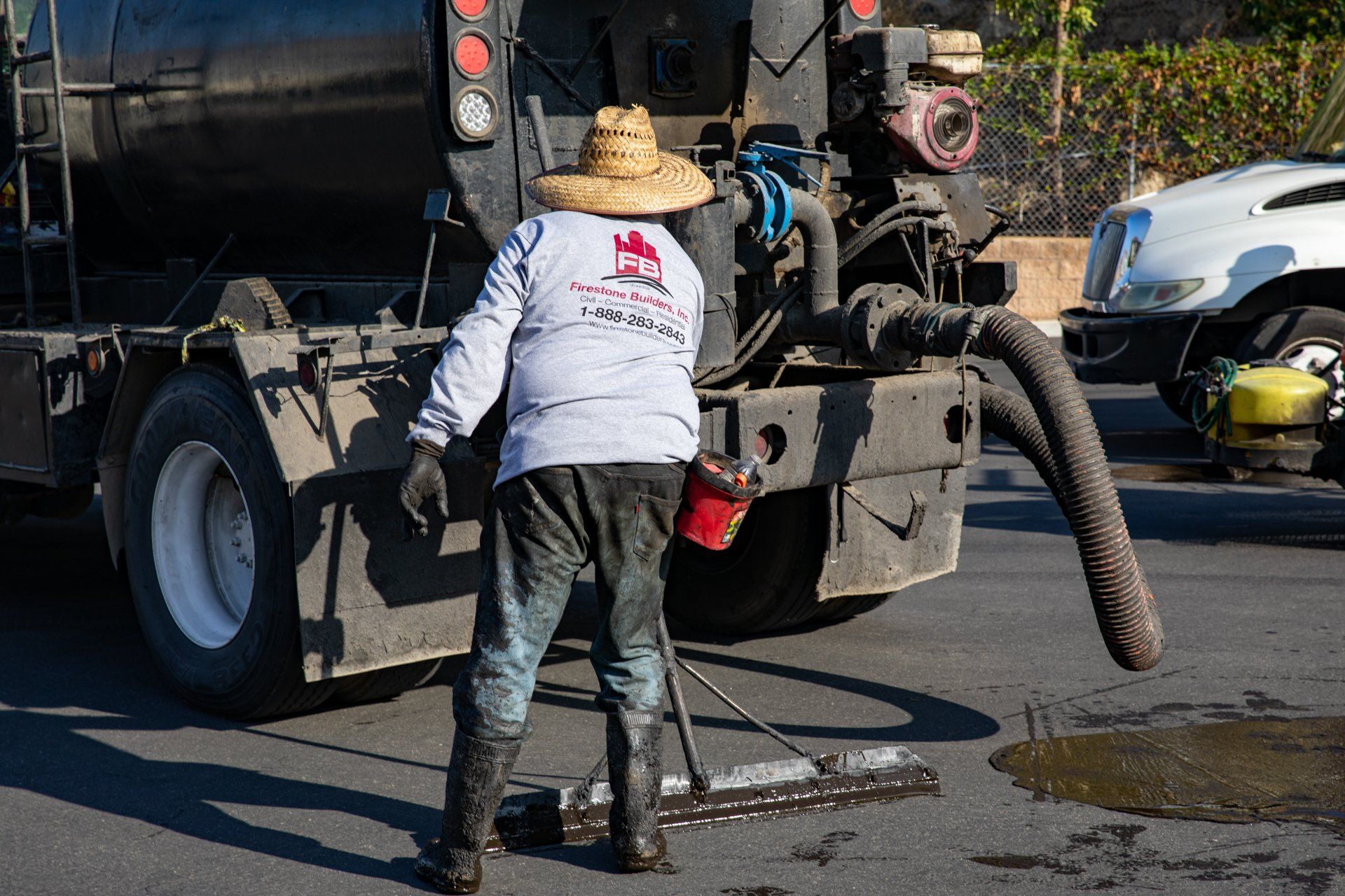 A man wearing a hat is standing in front of a truck.