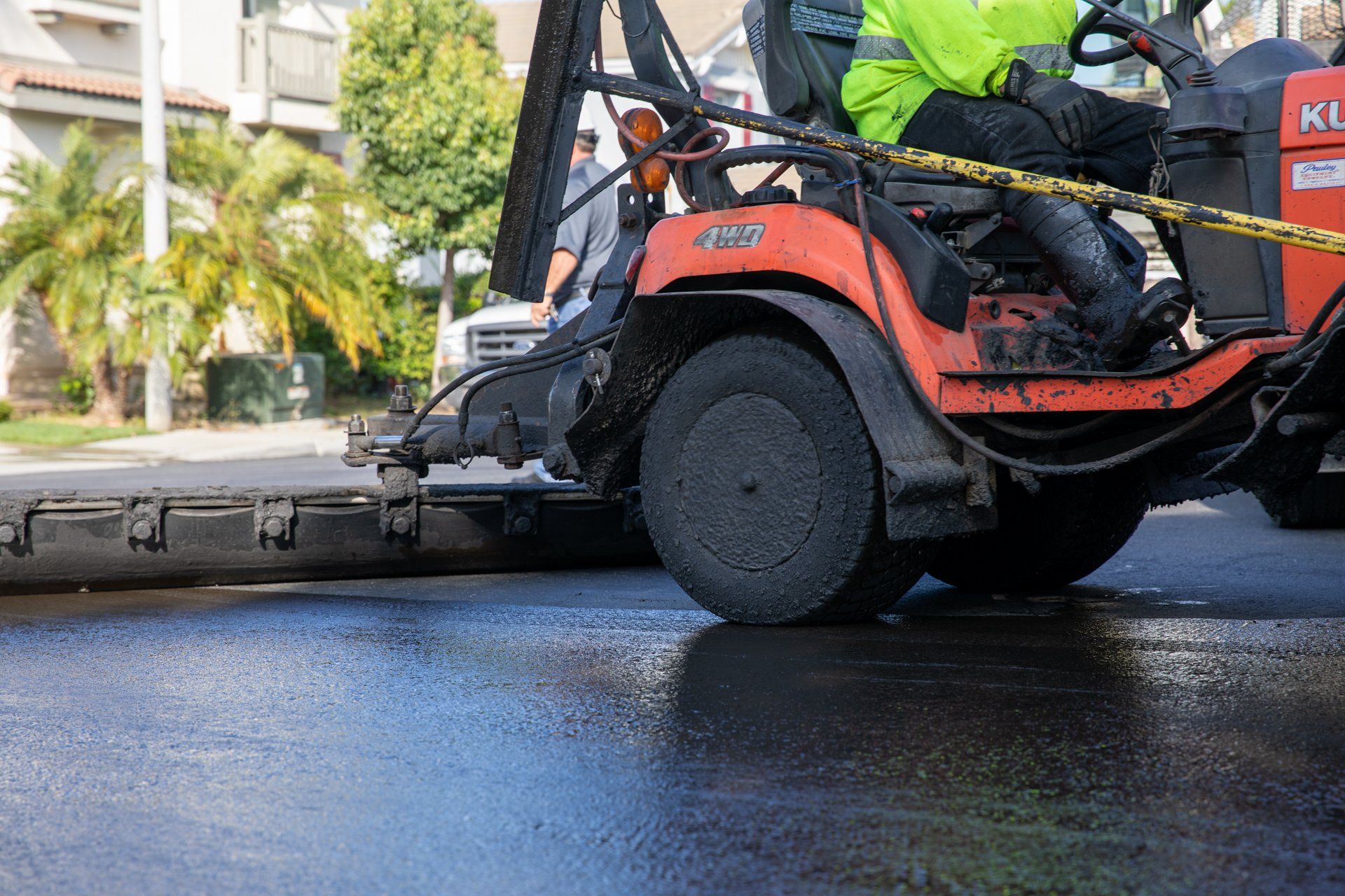 A man is driving a lawn mower on a street.