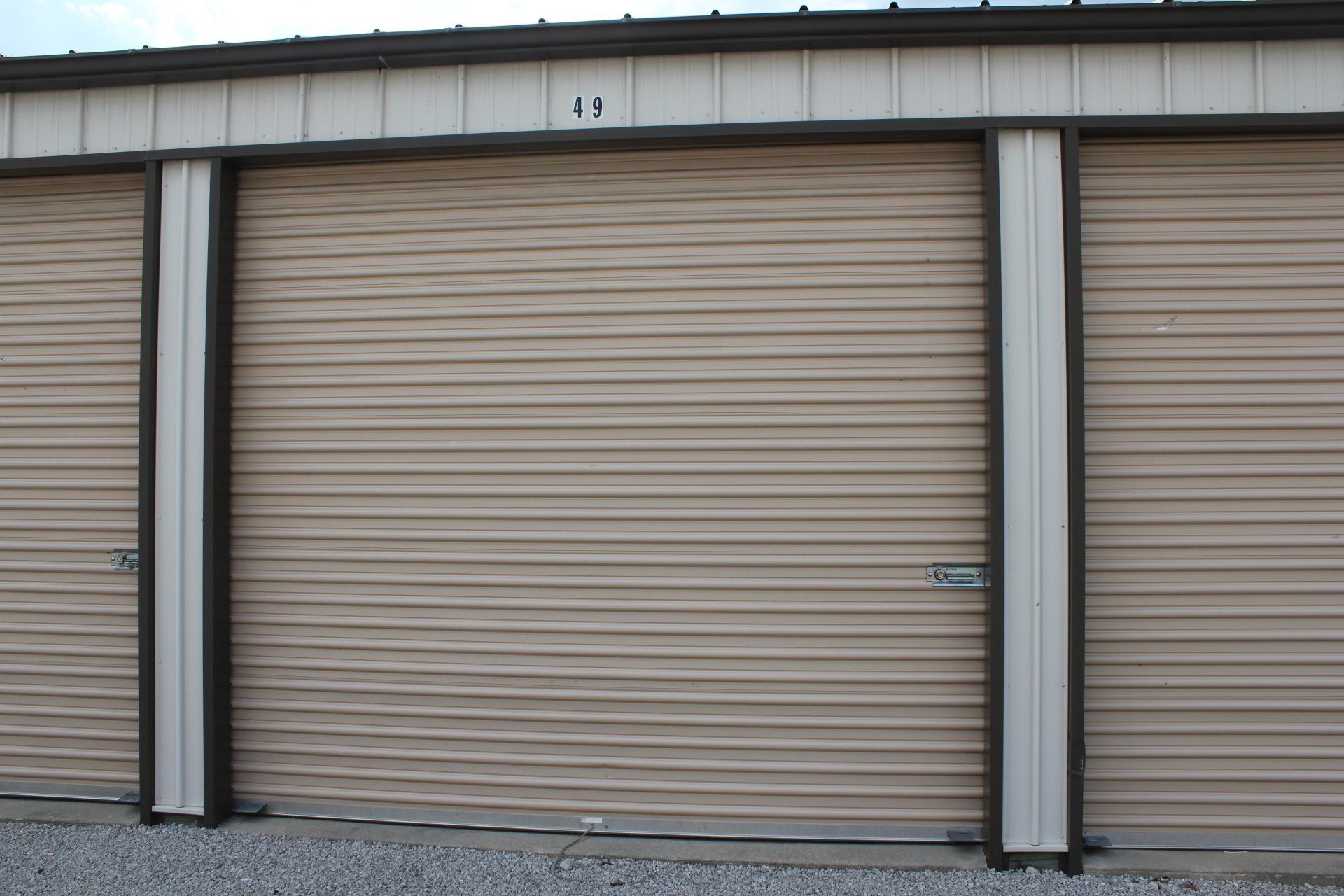 Storage unit doors, beige with dark trim, numbered 48, set in a row.
