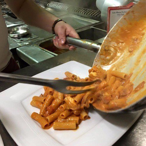 Il cuoco mettendo la pasta nel piatto