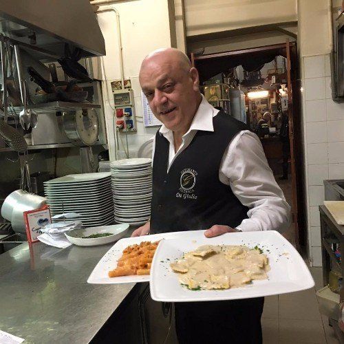 Il padrone con due pizze, una con mozzarella e l'altra con peperoni