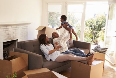 A family sits on the couch of their new home