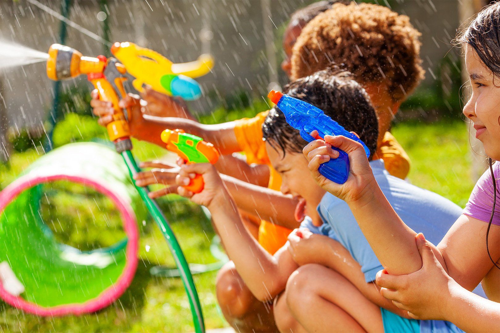 Boy with stuck out tongue in water gun fight game