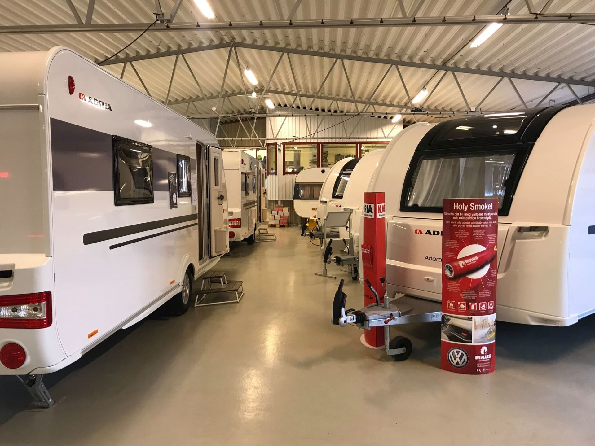 Caravans parked inside a dealership, with a red advertisement banner in the foreground.