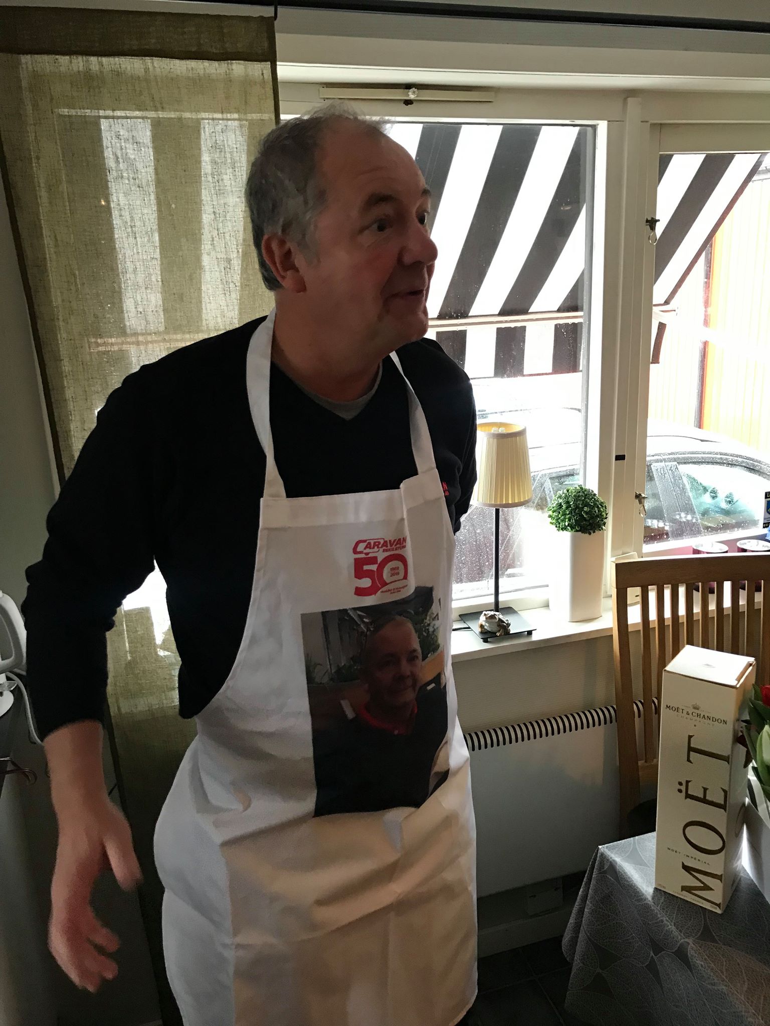 Man wearing a white apron with a photo and