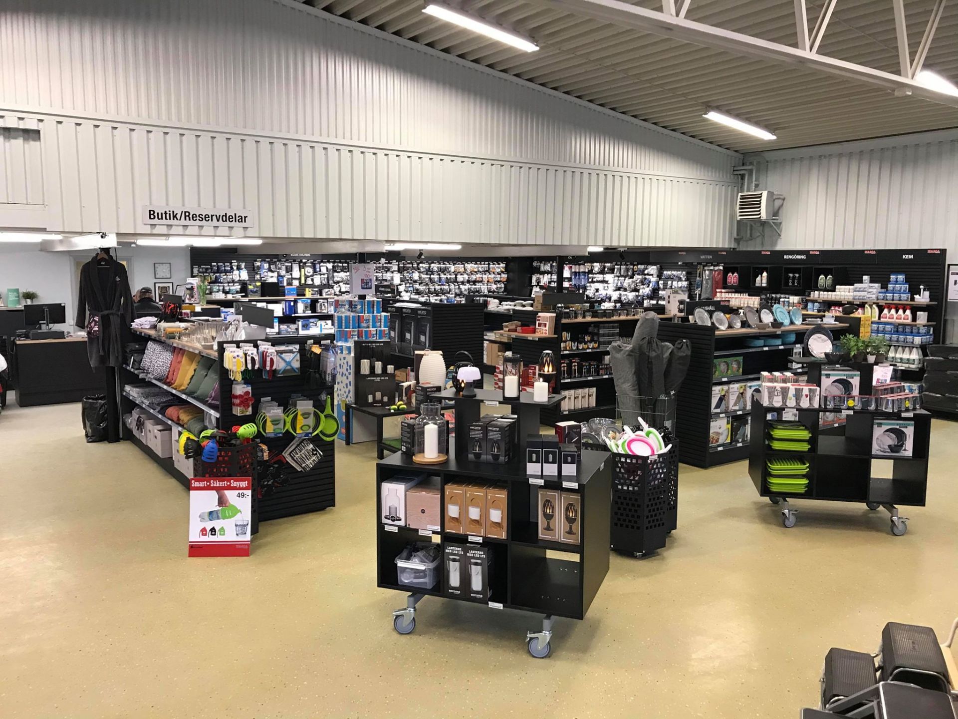 Inside a store filled with merchandise on black shelving and displays, including clothing and electronics.