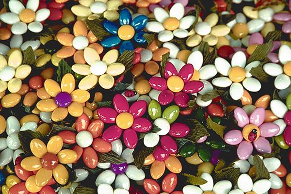 Nahaufnahme von bunten Bonbonblumen aus Mandelbonbons mit grünen Blattdekorationen.