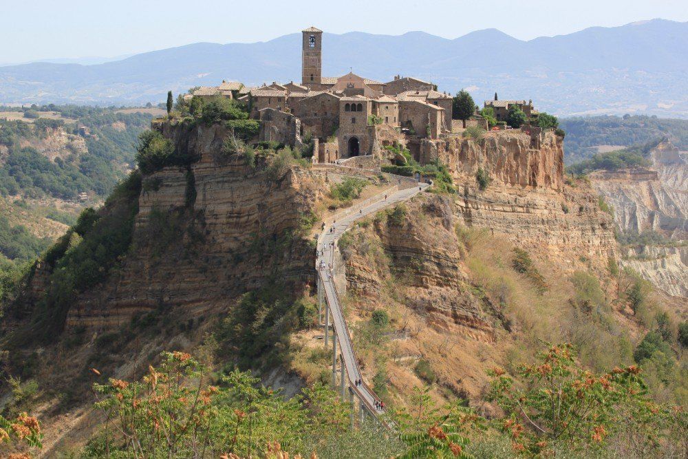Civita di Bagnoregio, eine mittelalterliche italienische Stadt auf einem Plateau, zu der eine Straße führt.