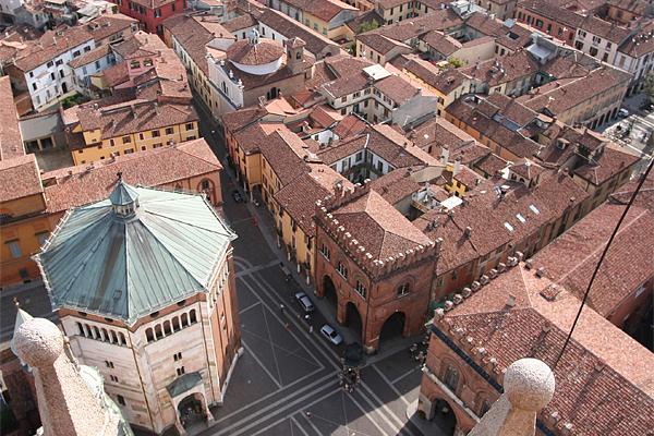 Luftaufnahme von Parma, Italien, mit Terrakotta-Dächern, einem großen Baptisterium mit Gründach und historischen Gebäuden