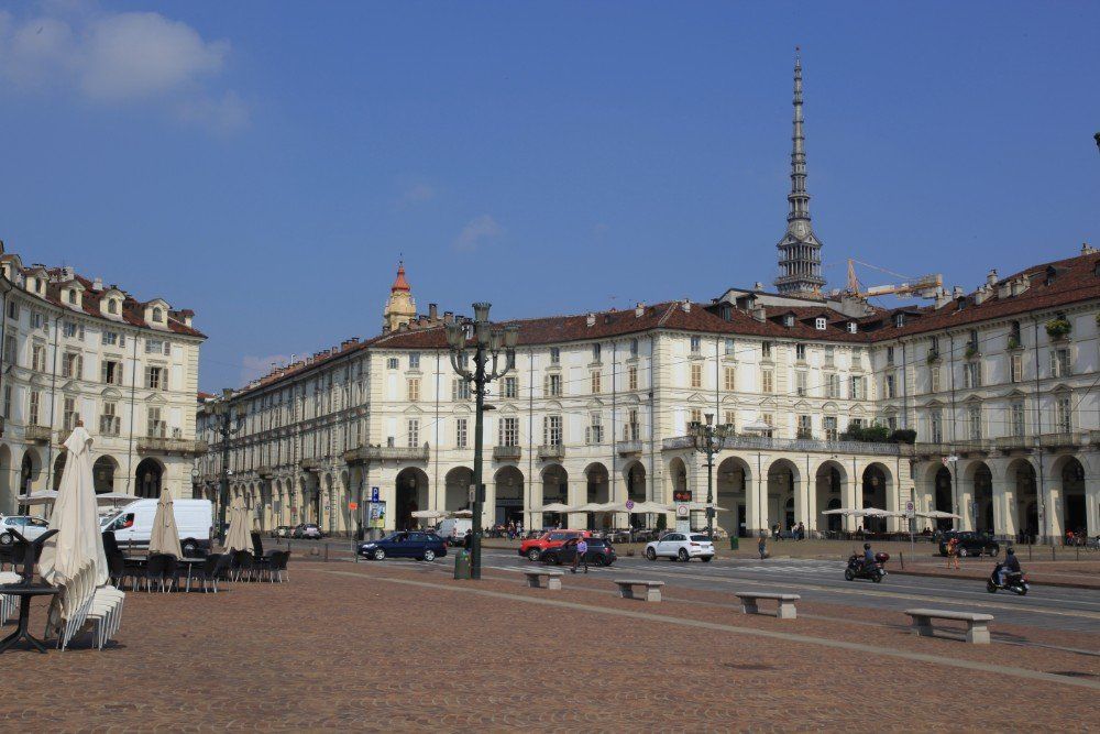 Großer Platz in Turin, Italien, gesäumt von kunstvollen Gebäuden.